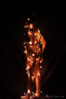naked woman wrapped in Christmas lights