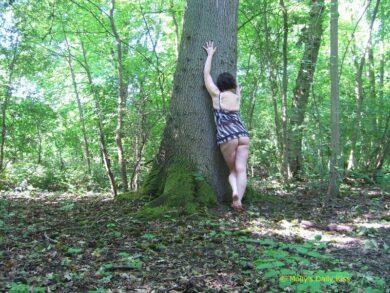 Molly in a negligee up against a tree