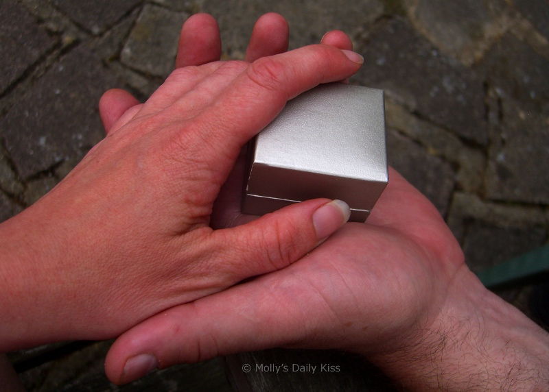 hands holding ring box