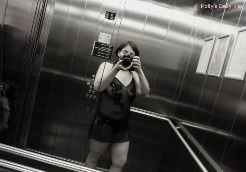 molly in lingerie talking self potrait in the mirrored walls of a elevator