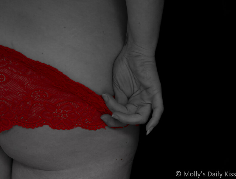 Molly sliding red panties down her bottom