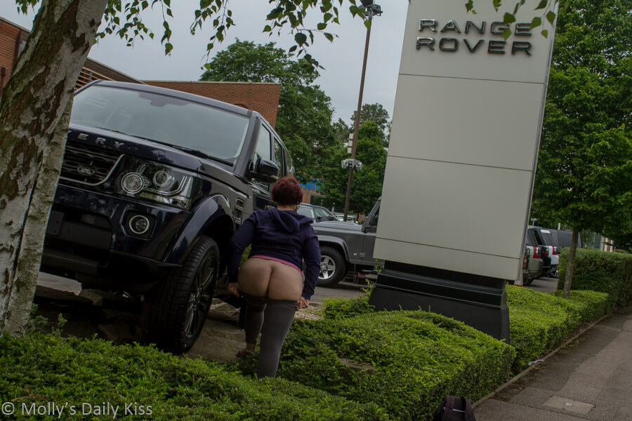 Molly flashing her bottom in front of Range Rover car showroom