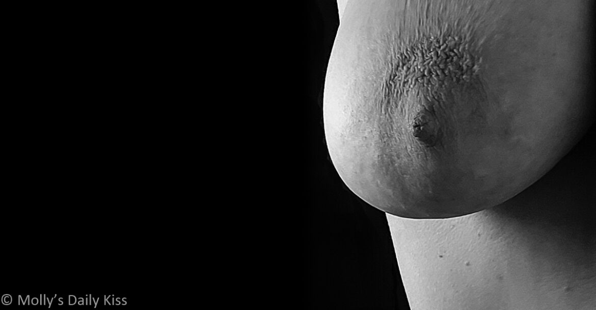 Cropped Black and white image of molly topless leaning into the image from the right. We can see her breast. The rest of the image is black for post called radical