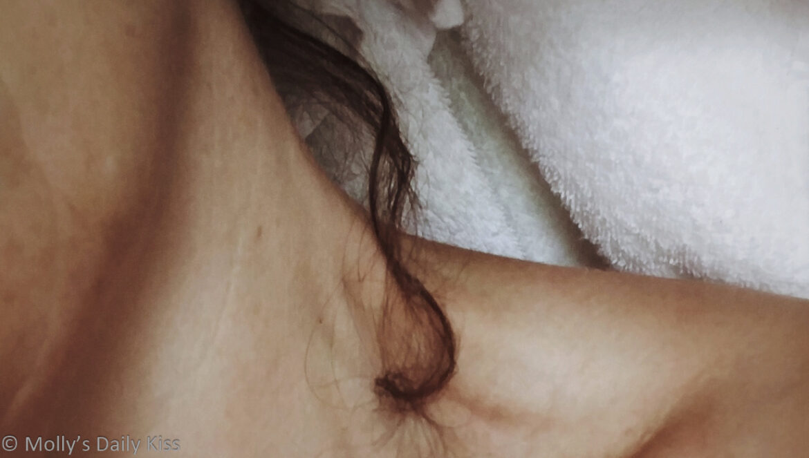 Cropped image of Small curl of hair snaking out from white towel round molly's neck